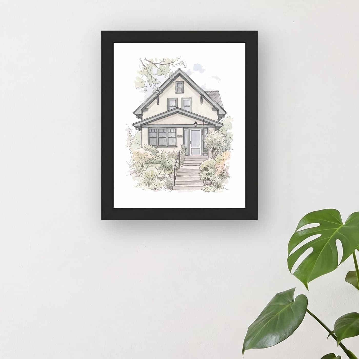 The framed 8 × 10 portrait in a black frame, hung on a wall above a console table.