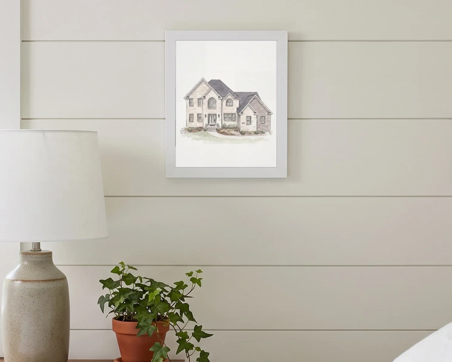 The framed portrait hanging on a bedroom wall above a nightstand.